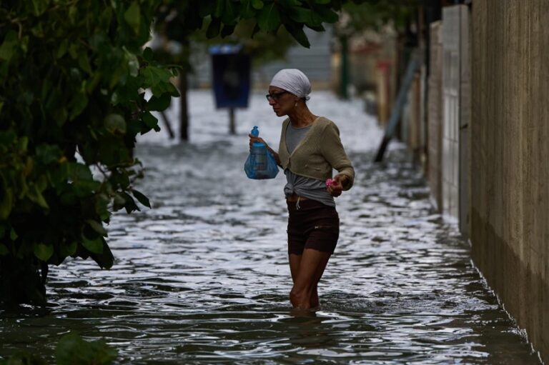 Una mujer camina por una calle inundada el domingo 1 de febrero de 2026, en La Habana. (AP Foto/Ramón Espinosa)